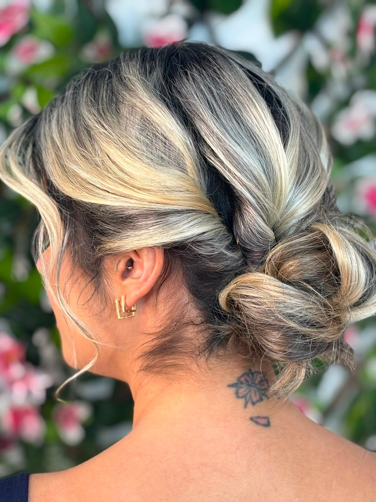 Make e penteado com coque lateral e iluminação dourada